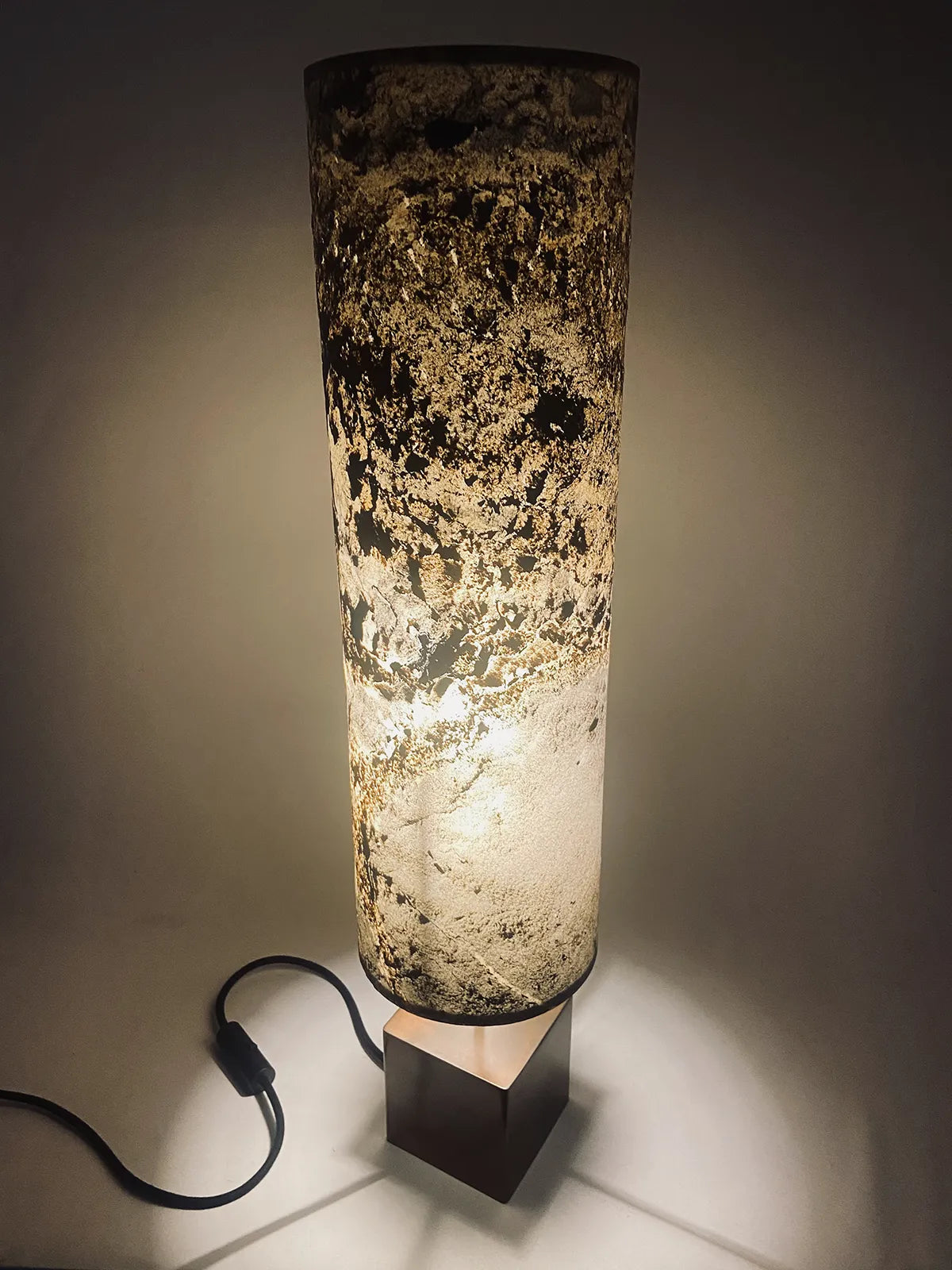 Lampe artisanale Halley Nova en acier cuivré et feuille d'ardoise rustique allumée vue en plongée. fabrication française par l'atelier Maus