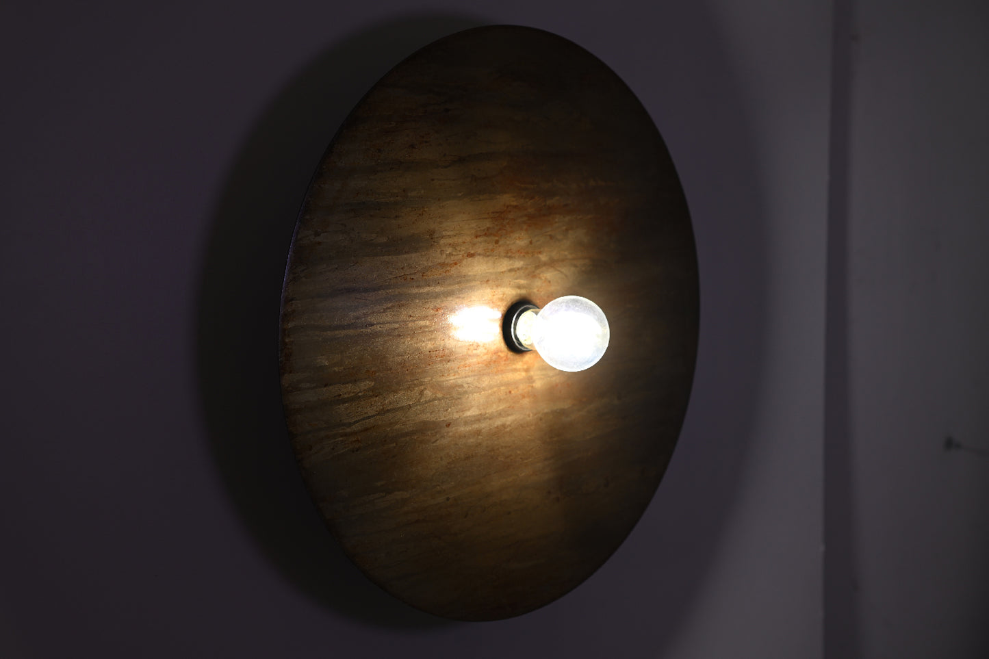 Vue frontale de l'applique Rovelli Oxydations révélant les nuances subtiles de la patine brun, doré et vert de gris