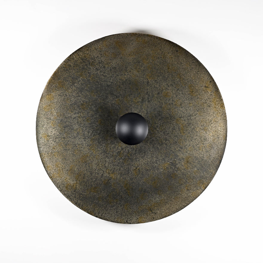 Applique Rovelli Ombres en acier oxydé montrant les nuances de noir, gris et brun de la patine