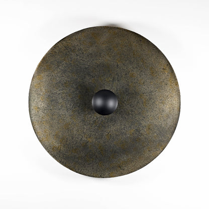 Applique Rovelli Ombres en acier oxydé montrant les nuances de noir, gris et brun de la patine