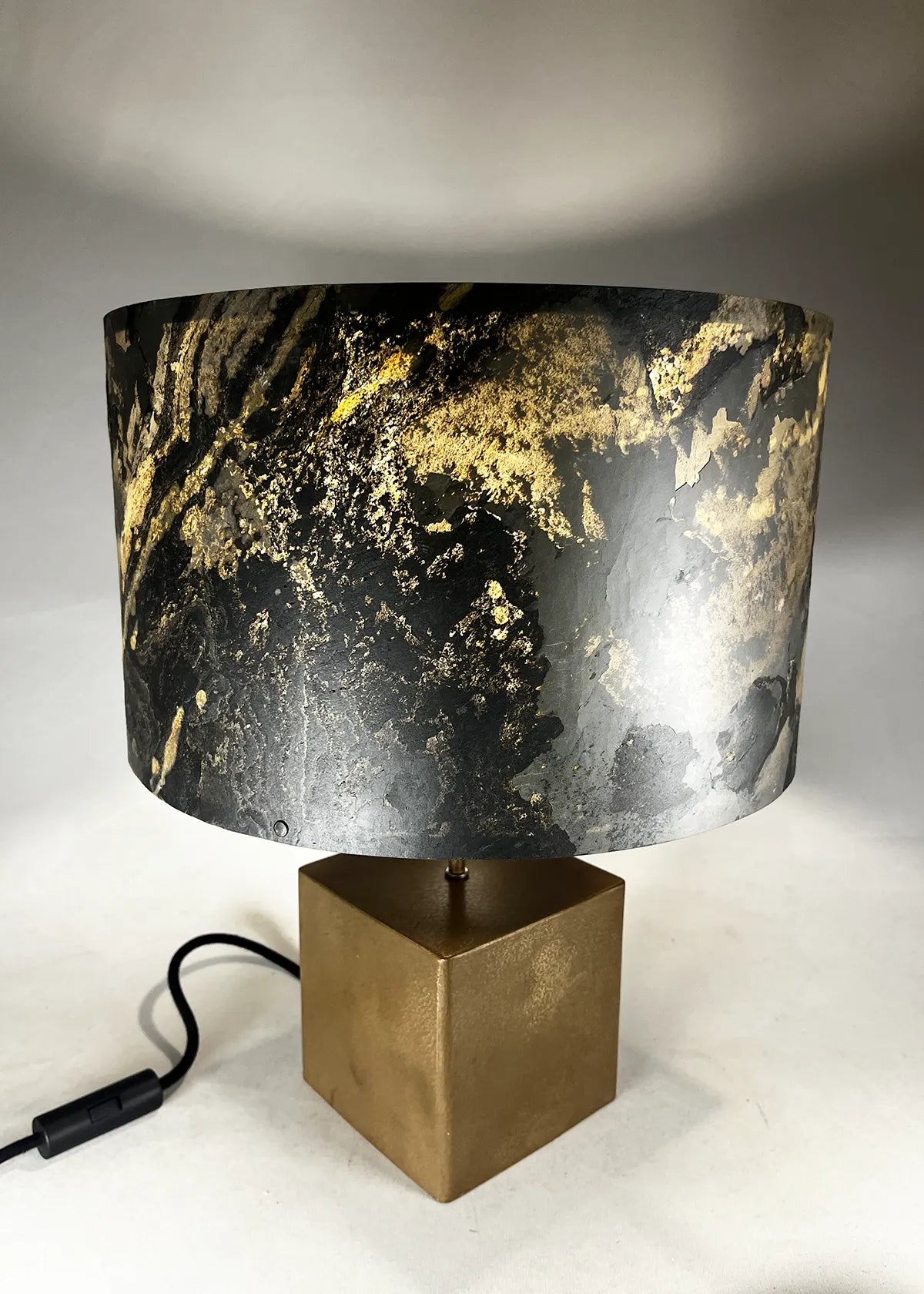 Lampe en acier revêtu de poudre de bronze et son abat-jour en feuille d'ardoise rustique allumée, modèle Cassini au style minimaliste wabi-sabi par l'atelier Maus