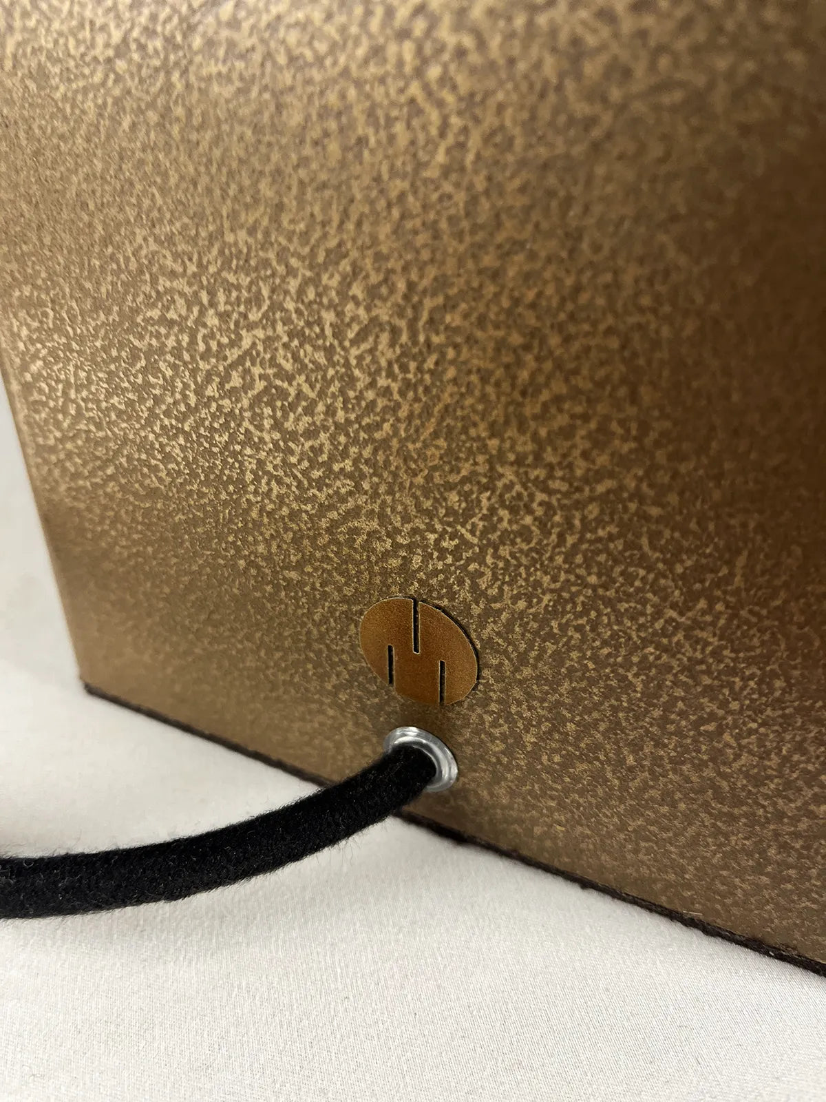 détail de l'arrière de la Lampe en acier revêtu de poudre de bronze, son cordon électrique en coton noir , passe-câble et logo de l'atelier Maus