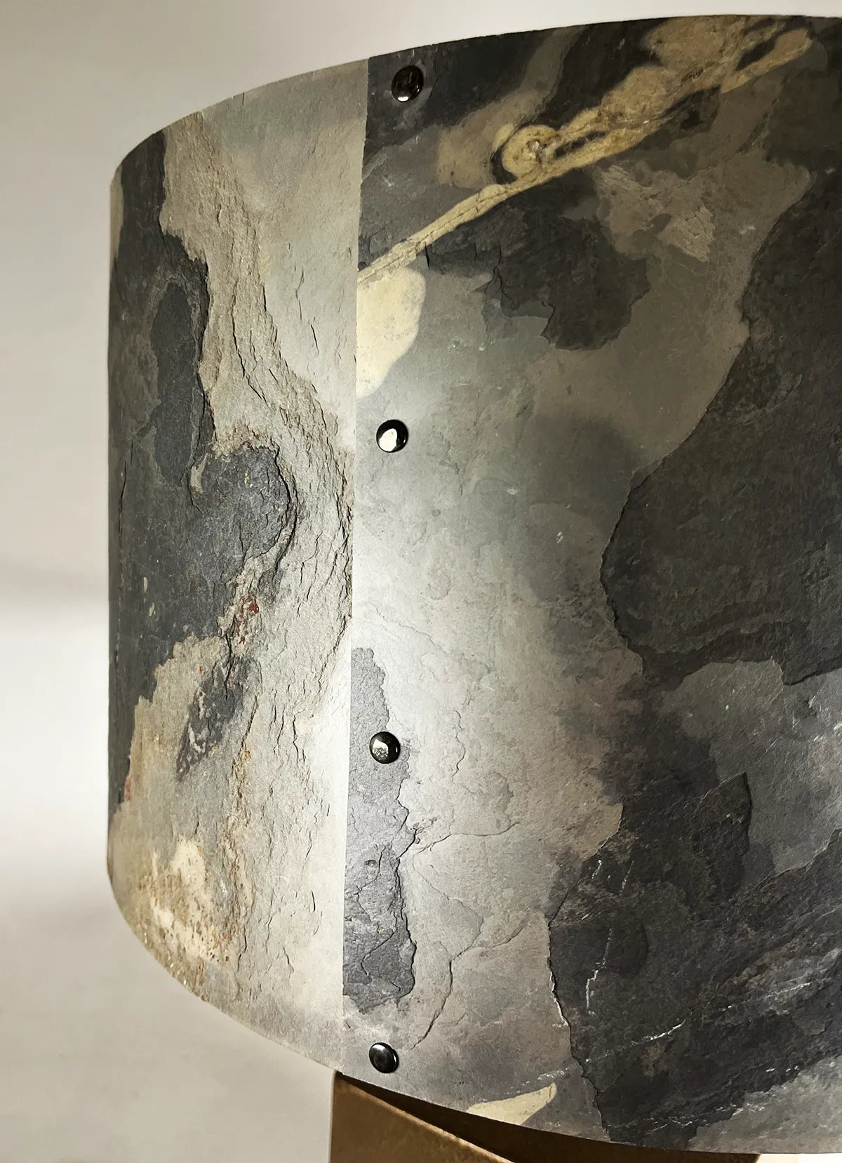 Détail de l'abat-jour en feuille d'ardoise rustique éteint, rivets de fixation en acier patiné, modèle Cassini au style wabi-sabi par l'atelier Maus