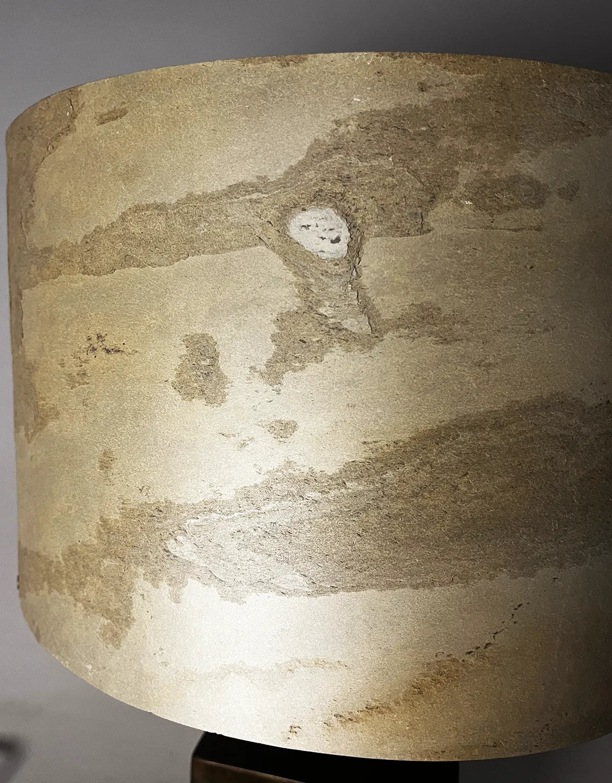 Vue rapprochée de l'abat-jour en feuille d'ardoise Tan aux nuances beiges, ocres et brunes de la lampe Cassini par l'atelier Maus