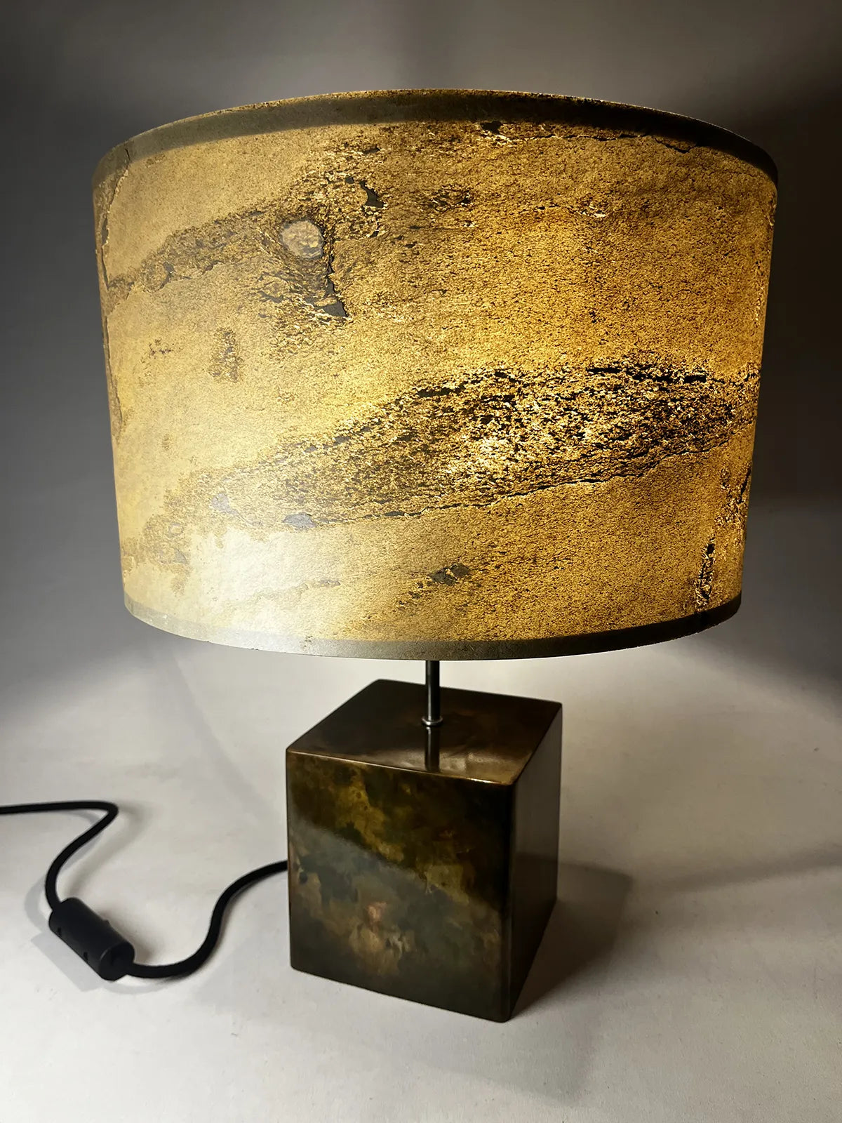 lampe sur pied Cassini de l'atelier Maus en feuille d'ardoise nuancée de beiges, ocres et bruns et son piètement en acier patiné irisé