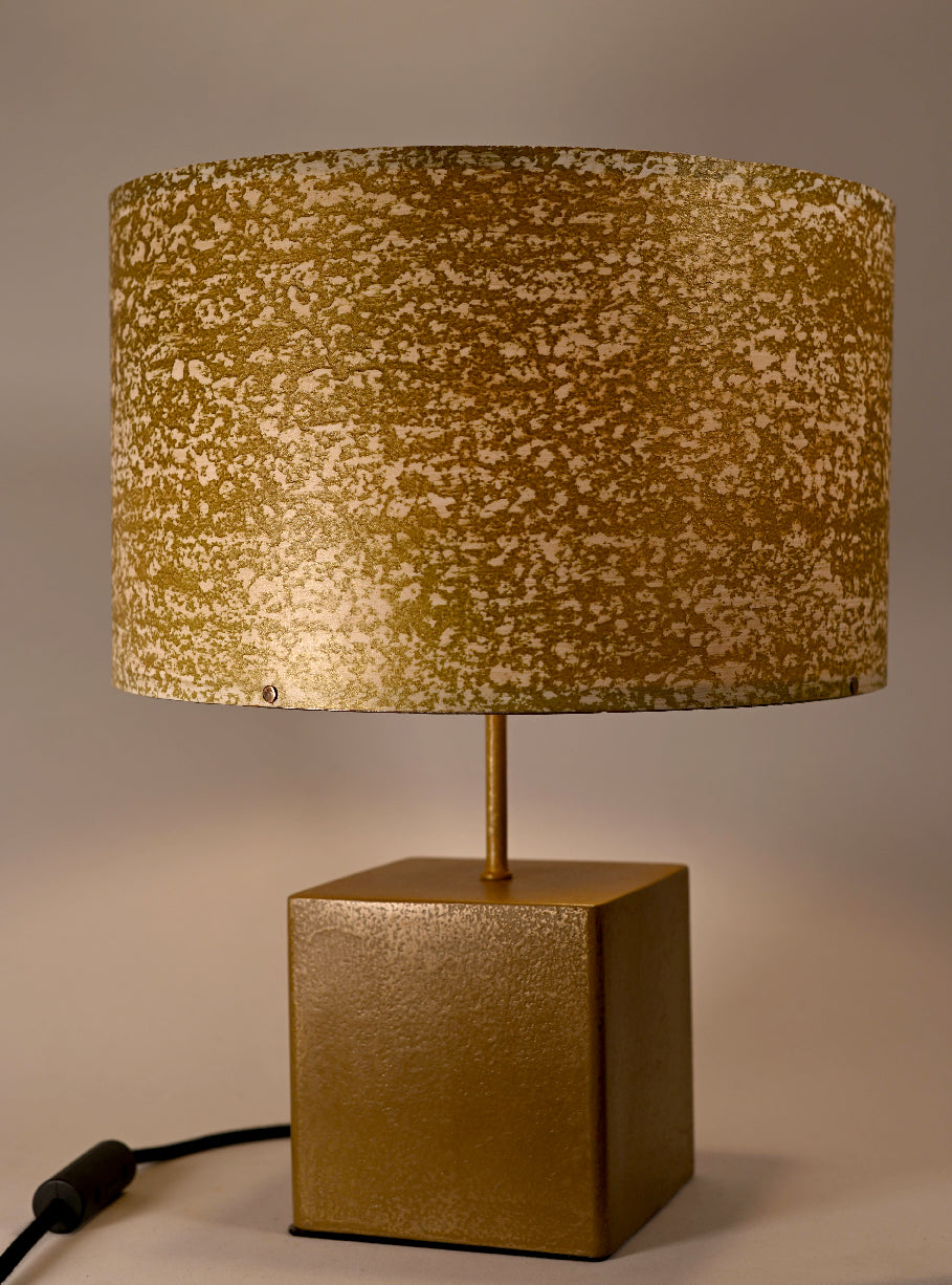 Vue rapprochée de l'abat-jour en feuille de mica blanc teinté or aux reflets dorés lumineux