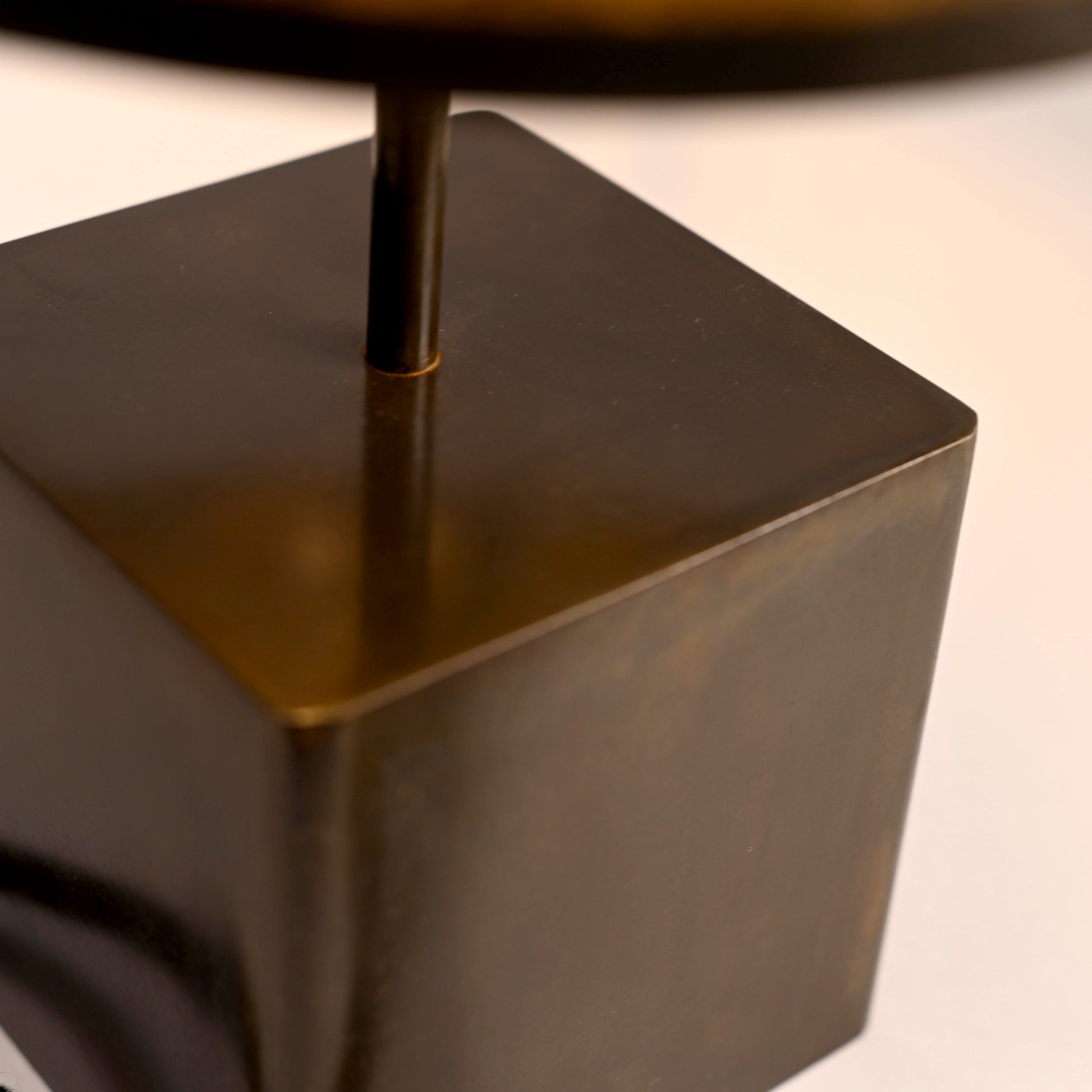 Détail de la patine noire brune du cube en acier de la lampe Halley Aura