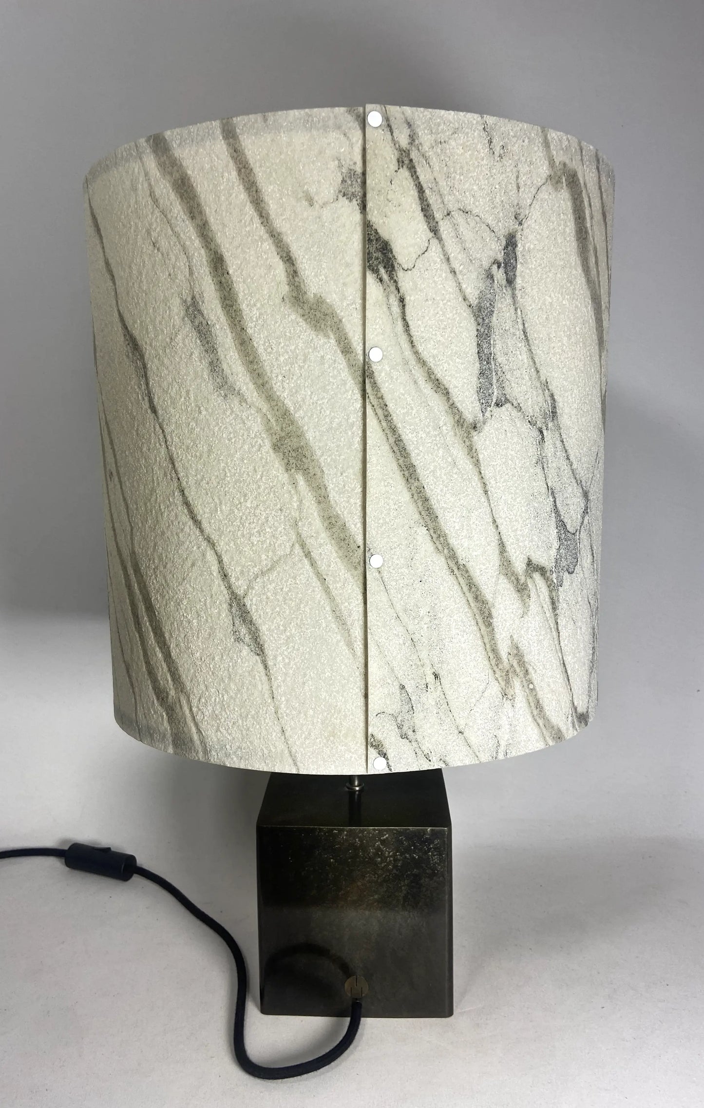 Vue arrière de la Lampe Cassini Nova en acier patiné brun noir , abat-jour en feuille de  marbre statuaire assemblé par rivets blancs. Pièce unique de Fabrication française Atelier Maus
