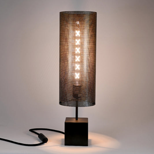 Lampe Halley Halo allumée diffusant une lumière douce et tamisée à travers la tôle perforée