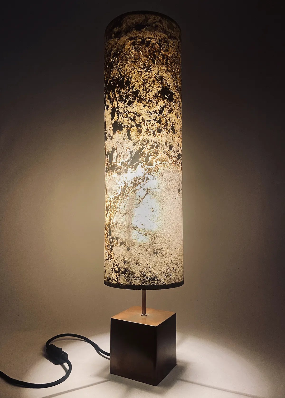 Lampe artisanale Halley Nova en acier cuivré et feuille d'ardoise rustique allumée. fabrication française par l'atelier Maus Taille H
