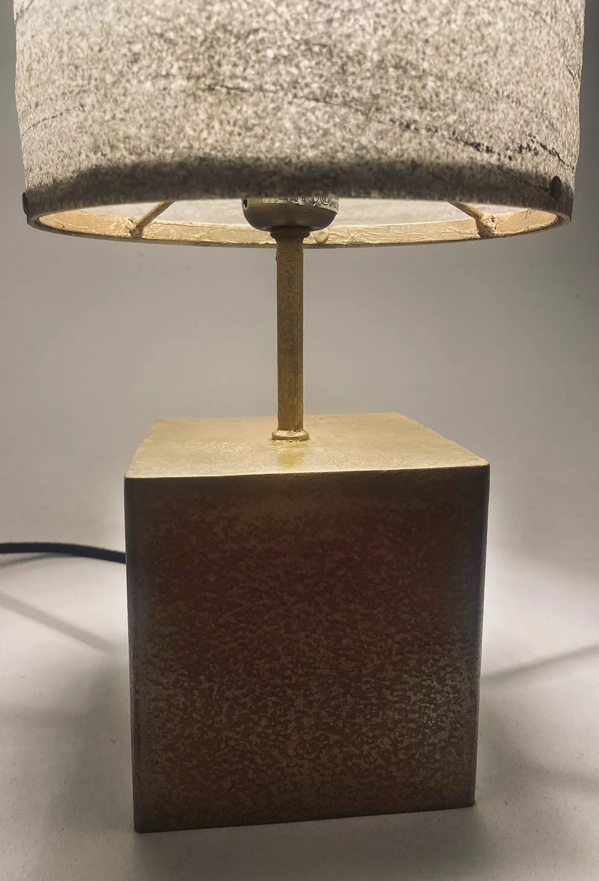Vue de détail de la lampe en acier laitonné et abat-jour en marbre statuario. pièce unique de l'atelier aus. Fabriqué en France
