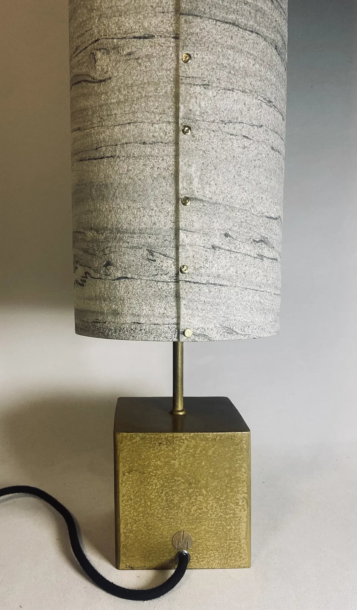 Vue de détail du dos de la lampe en acier laitonné et abat-jour en marbre statuario. pièce unique de l'atelier Maus. Fabriqué en France