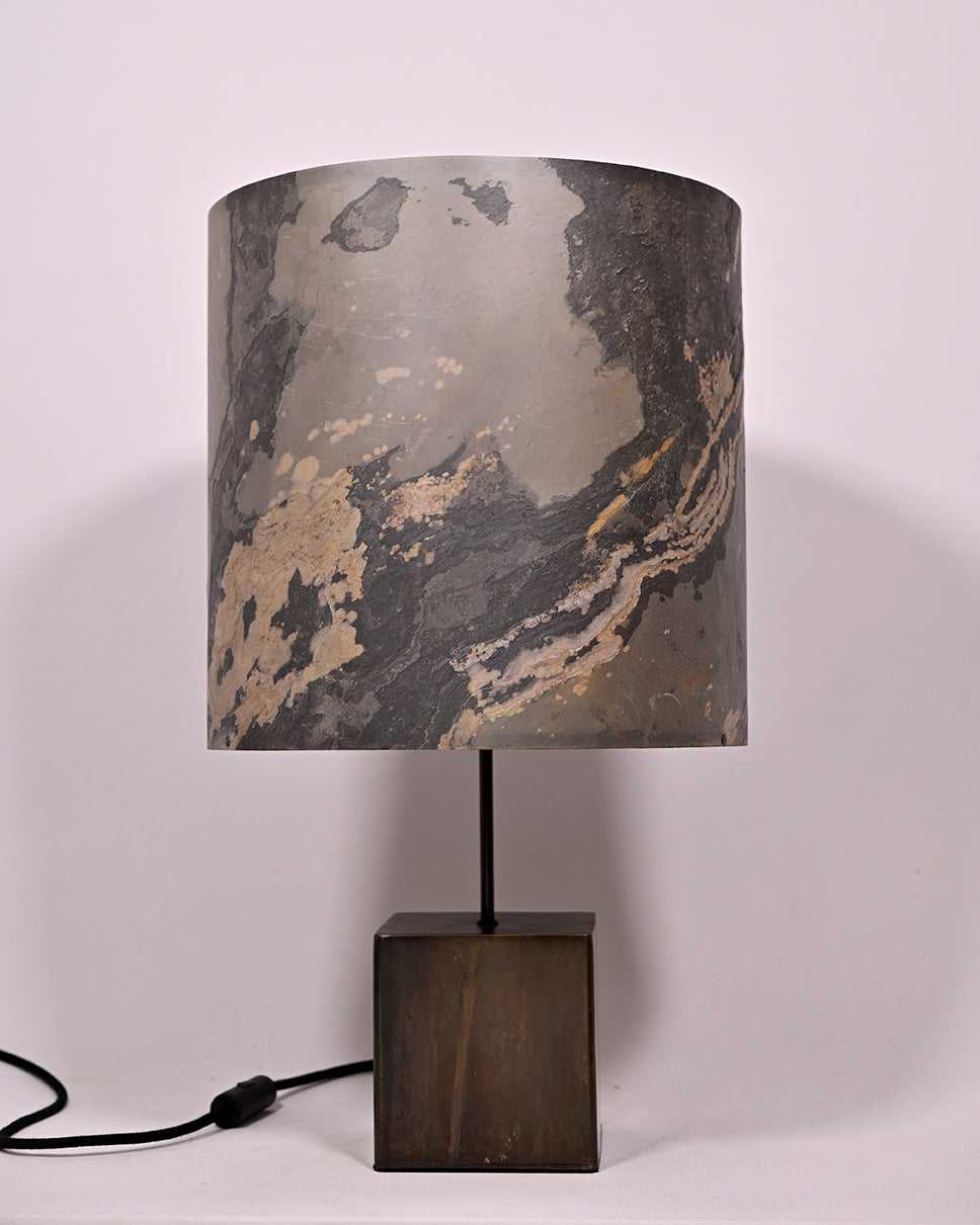 Vue de face d'une lampe en acier. Abat-jour en feuille d'ardoise rustique. Atelier Maus