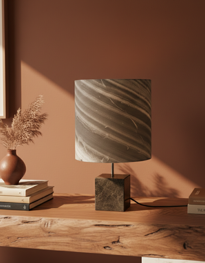 Scène en interieur de la Lampe à poser artisanale Cassini Nova acier patiné et feuille de marbre cipollino de l'atelier Maus. Fabriquée en France