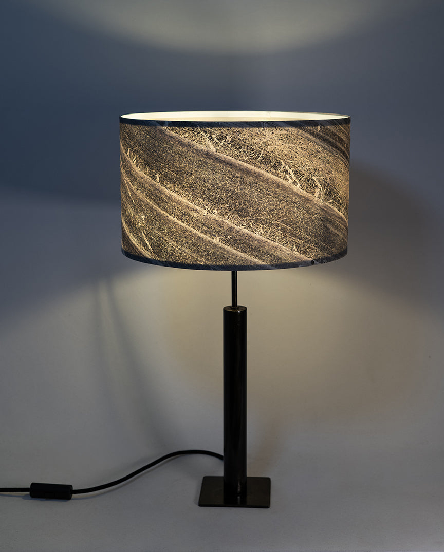 Photo en gros plan de la lampe Rosalynd en acier patiné et feuille de marbre allumée
 | Atelier Maus