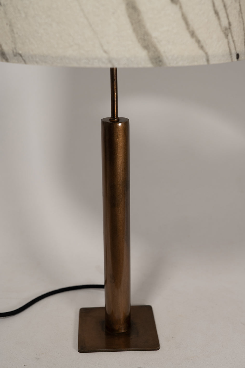 Photo en gros plan du pied de la lampe Rosalynd en acier cuivré et feuille de marbre Statuario | Atelier Maus