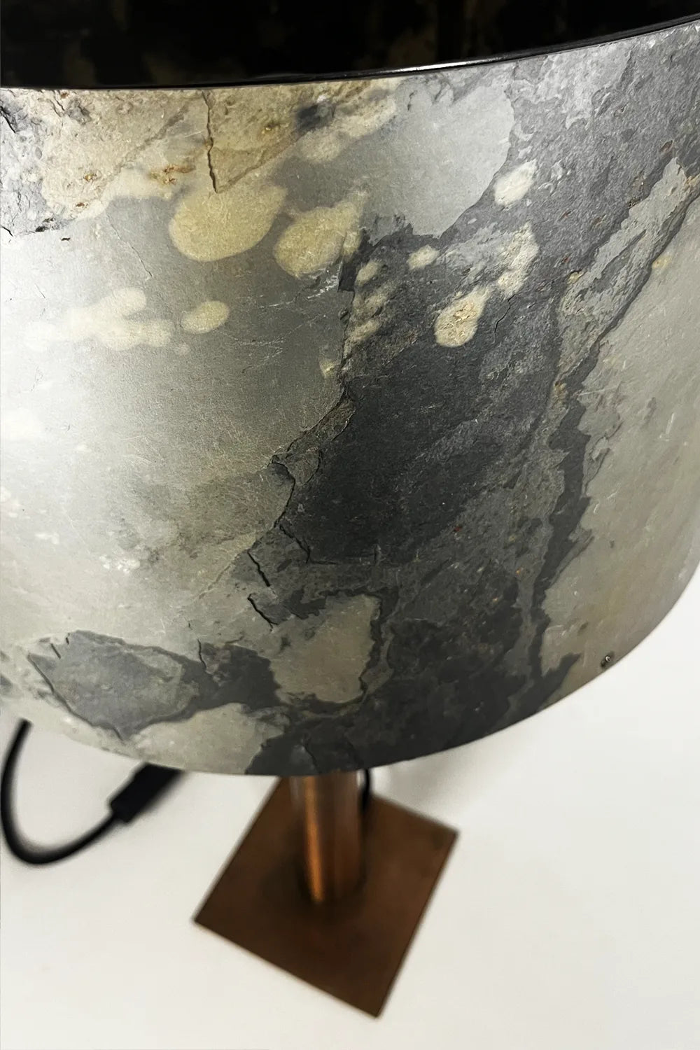 Détail de l’abat-jour en ardoise rustique et du piètement en acier cuivré d’une lampe Rosalynd