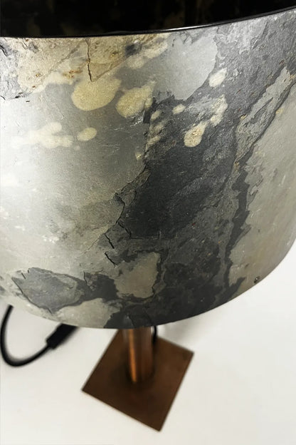Détail de l’abat-jour en ardoise rustique et du piètement en acier cuivré d’une lampe Rosalynd