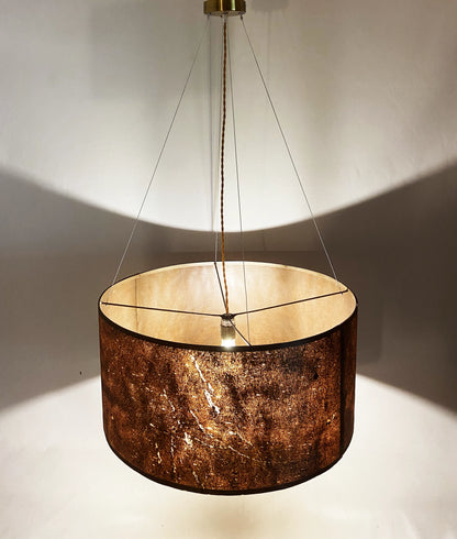 Vue en hauteur de la suspension en feuille de mica cuivré Thessalie par l'atelier Maus allumée. Rosace et carcasse en acier cuivré, suspendue par 4 cables inox de longueur réglable. Pièce artisanale unique de fabrication française.
