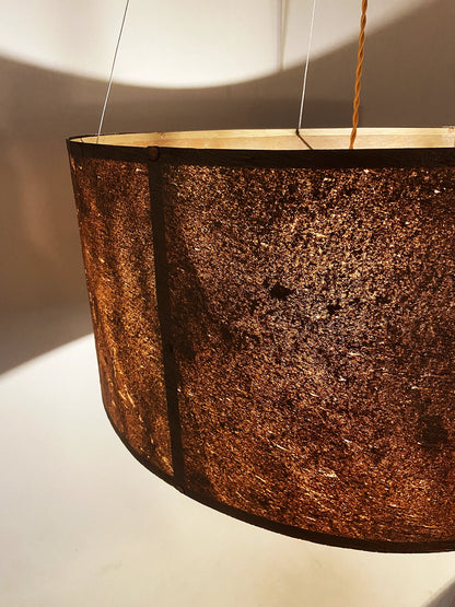 Détail de la suspension en feuille de mica cuivré Thessalie par l'atelier Maus allumée. Rosace et carcasse en acier cuivré, suspendue par 4 cables inox de longueur réglable. Pièce artisanale unique de fabrication française.