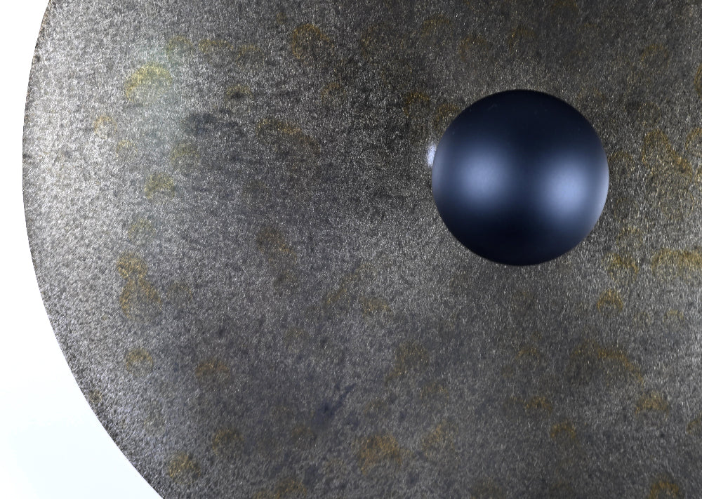 Gros plan sur la texture et les nuances sombres de la finition oxydée de l'applique Rovelli Ombres