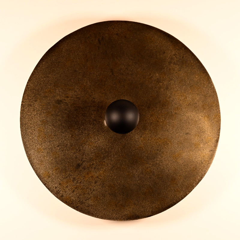 Détail des reliefs et des effets de matière de l'acier patiné de l'applique murale Rovelli Ombres