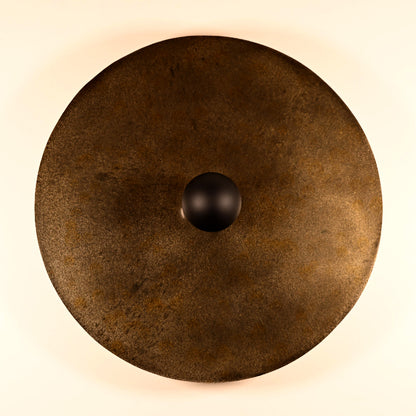 Détail des reliefs et des effets de matière de l'acier patiné de l'applique murale Rovelli Ombres