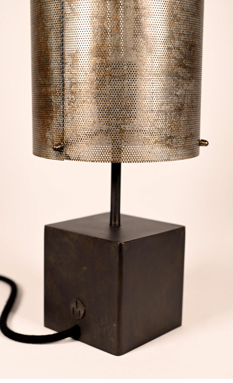 Détail des micro-perforations de l'abat-jour en tôle oxydée et de la patine noire