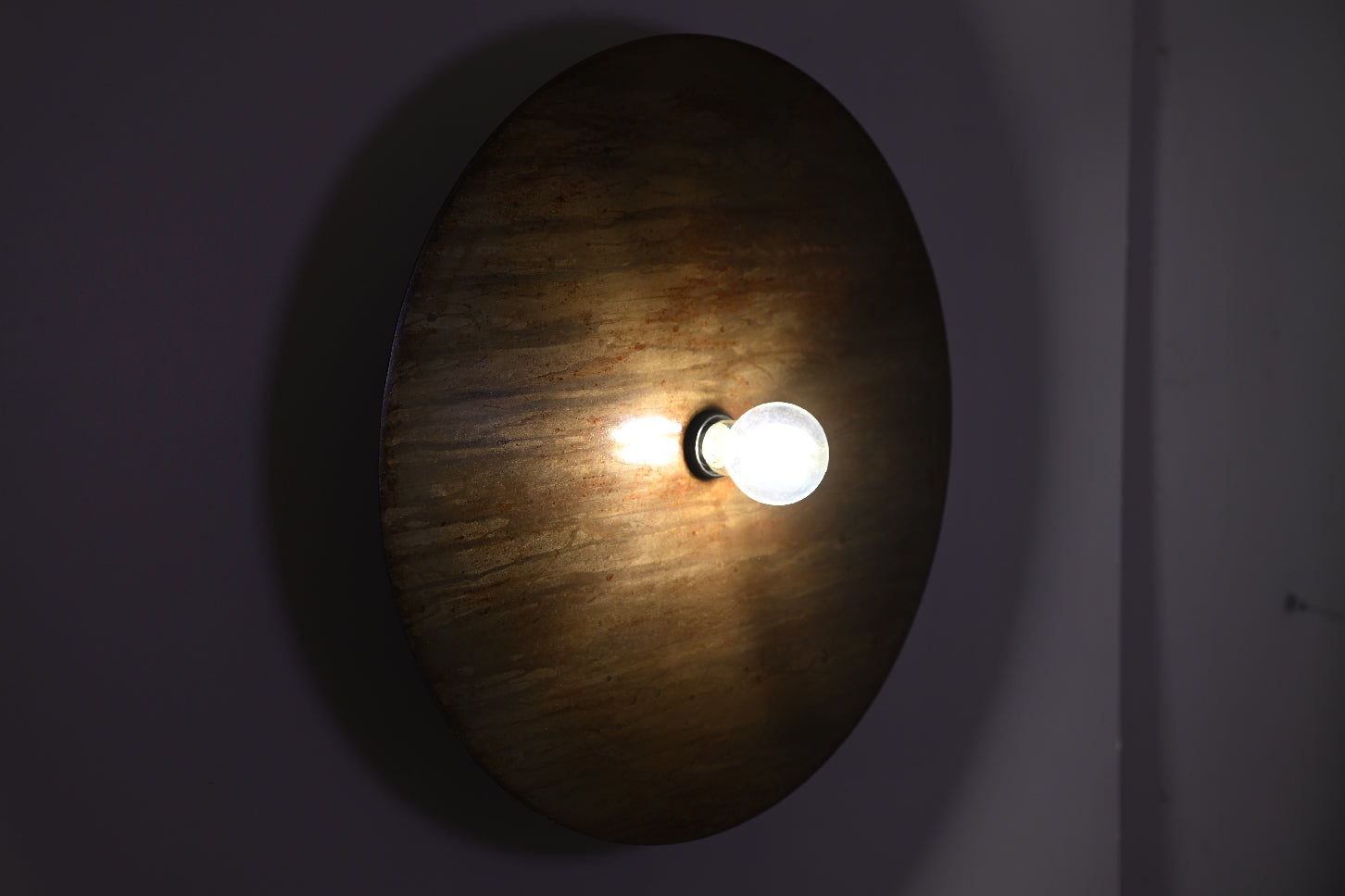 Vue frontale de l'applique Rovelli Oxydations révélant les nuances subtiles de la patine brun, doré et vert de gris