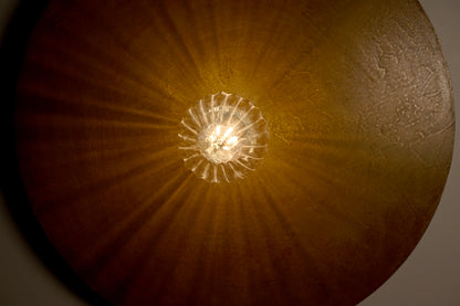 Détail de la finition poudre de laiton et des effets de matière de l'applique Rovelli