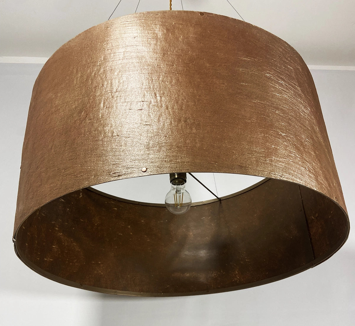 Vue de dessous de la suspension en feuille de mica cuivré Thessalie par l'atelier Maus éteinte. Rosace et carcasse en acier cuivré, suspendue par 4 cables inox de longueur réglable. Pièce artisanale unique de fabrication française.