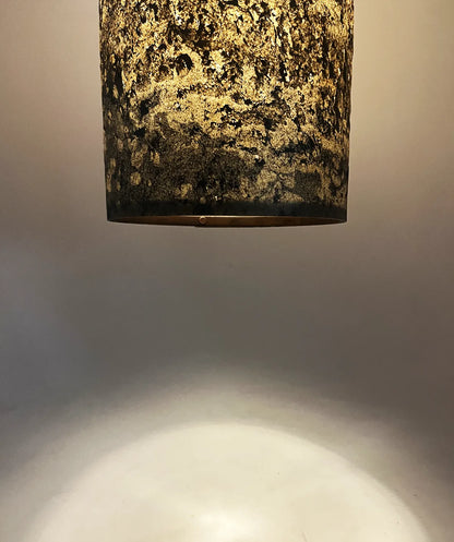 détail de la suspension en feuille d'ardoise rustique Swan allumée, texture minérale. Atelier Maus