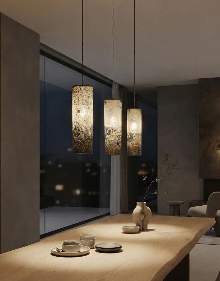  3 suspensions en feuille d'ardoise rustique Swan allumées au dessus d'une table à manger dans un intérieur contemporain,  Style wabi-sabi. Atelier Maus