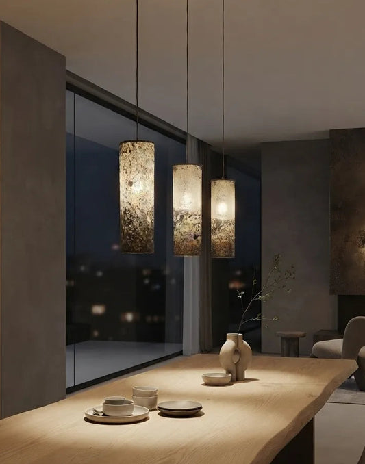  3 suspensions en feuille d'ardoise rustique Swan allumées au dessus d'une table à manger dans un intérieur contemporain,  Style wabi-sabi. Atelier Maus